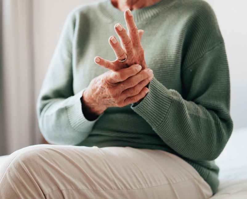 Frau hält sich die schmerzende Hand
