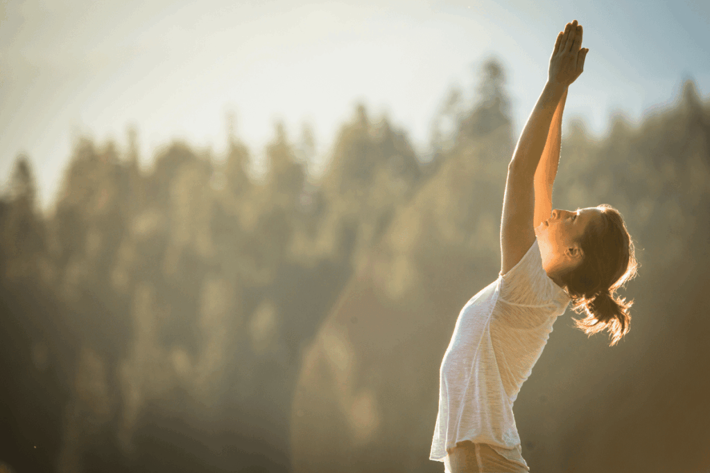 Frau macht Yoga in der Natur, um Nervensystem zu beruhigen