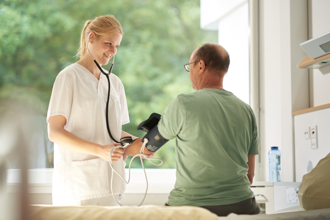 Frau misst den Puls eines Patienten