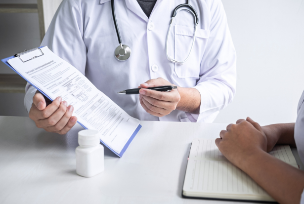 Ein Arzt zeigt einem Patienten den Behandlungsplan